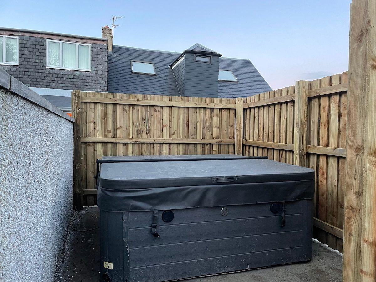 The hot tub in the enclosed yard